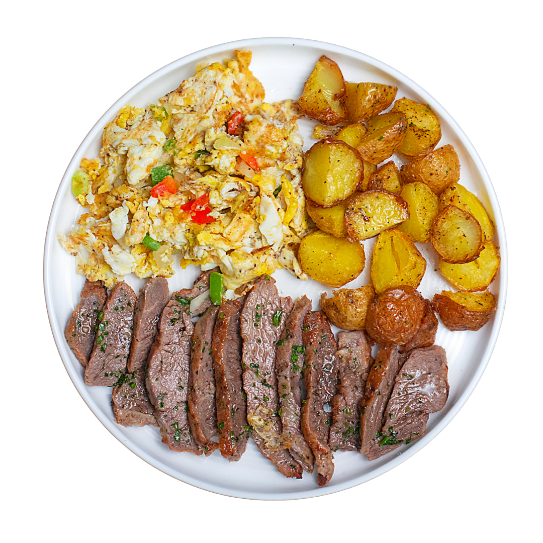 Plate of sliced steak with scrambled eggs and roasted potatoes on a white background