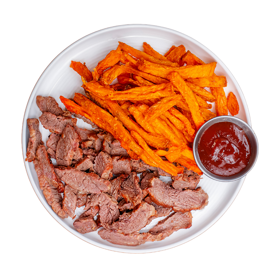 Plate of sliced beef with sweet potato fries and a side of ketchup on a white background